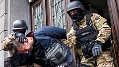 Members of the special police unit of Canton Sarajevo escort a person arrested in an operation codenamed "Black Tie" in Sarajevo, Bosnia, Monday, April 22, 2024