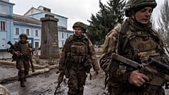 FILE PHOTO - Ukrainian servicemen who recently returned from the trenches of Bakhmut walk on a street in Chasiv Yar, Ukraine, Wednesday, March 8, 2023.