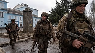 FILE PHOTO - Ukrainian servicemen who recently returned from the trenches of Bakhmut walk on a street in Chasiv Yar, Ukraine, Wednesday, March 8, 2023.