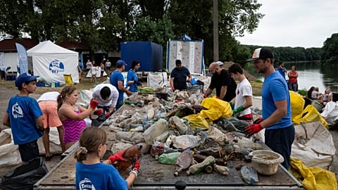 Volunteers in Hungary clear waste plastic from a river.