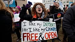 Lindsay Chestnut of Baltimore holds a sign that reads "I like My Internet Like I Like my Country: Free & Open".