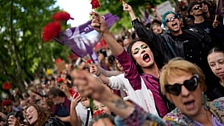 Pessoas com cravos vermelhos gritam "Fascismo nunca mais!" enquanto marcham pela Avenida da Liberdade, em Lisboa, para celebrar o 50º aniversário da Revolução dos Cravos Cr