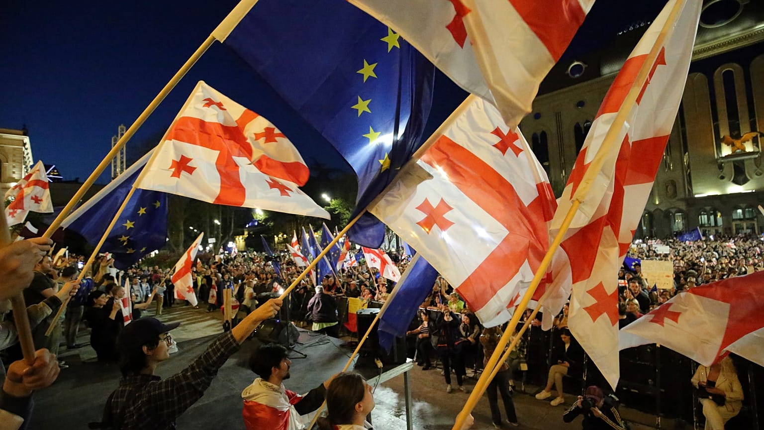 Des manifestants brandissent des drapeaux de la Géorgie et de l'UE alors qu'ils se rassemblent devant le bâtiment du parlement à Tbilissi le 17 avril 2024