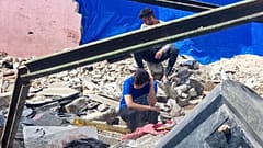 فلسطينيون ينظرون إلى الدمار الذي خلفته غارة جوية إسرائيلية على مدينة رفح في قطاع غزة.