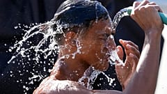 Ein Mann übergießt sich entlang einer Straße mit Wasser, während die Hitzewelle in Manila anhält. 