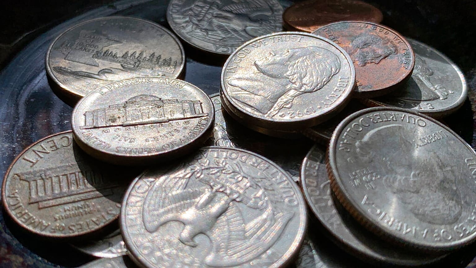 Los cuartos, monedas de cinco, diez y centavos se colocan en un tazón el jueves 31 de marzo de 2022 en Tigard, Oregon. 