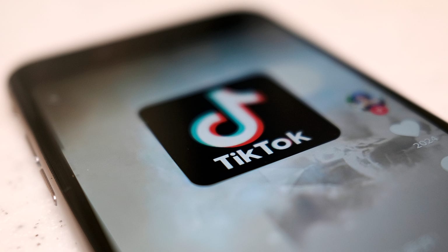 Um logótipo de uma aplicação para smartphone TikTok é visto numa publicação de utilizador no ecrã de um smartphone