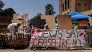 Manifestantes propalestinos refuerzan unas barricadas alrededor de su campamento en el campus de la Universidad de California en Los Ángeles (UCLA) el martes 30 de abril