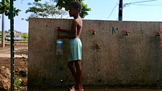 A boy fills up a bottle at the water fountain in M'tsamoudou, near Bandrele on the French Indian Ocean territory of Mayotte.