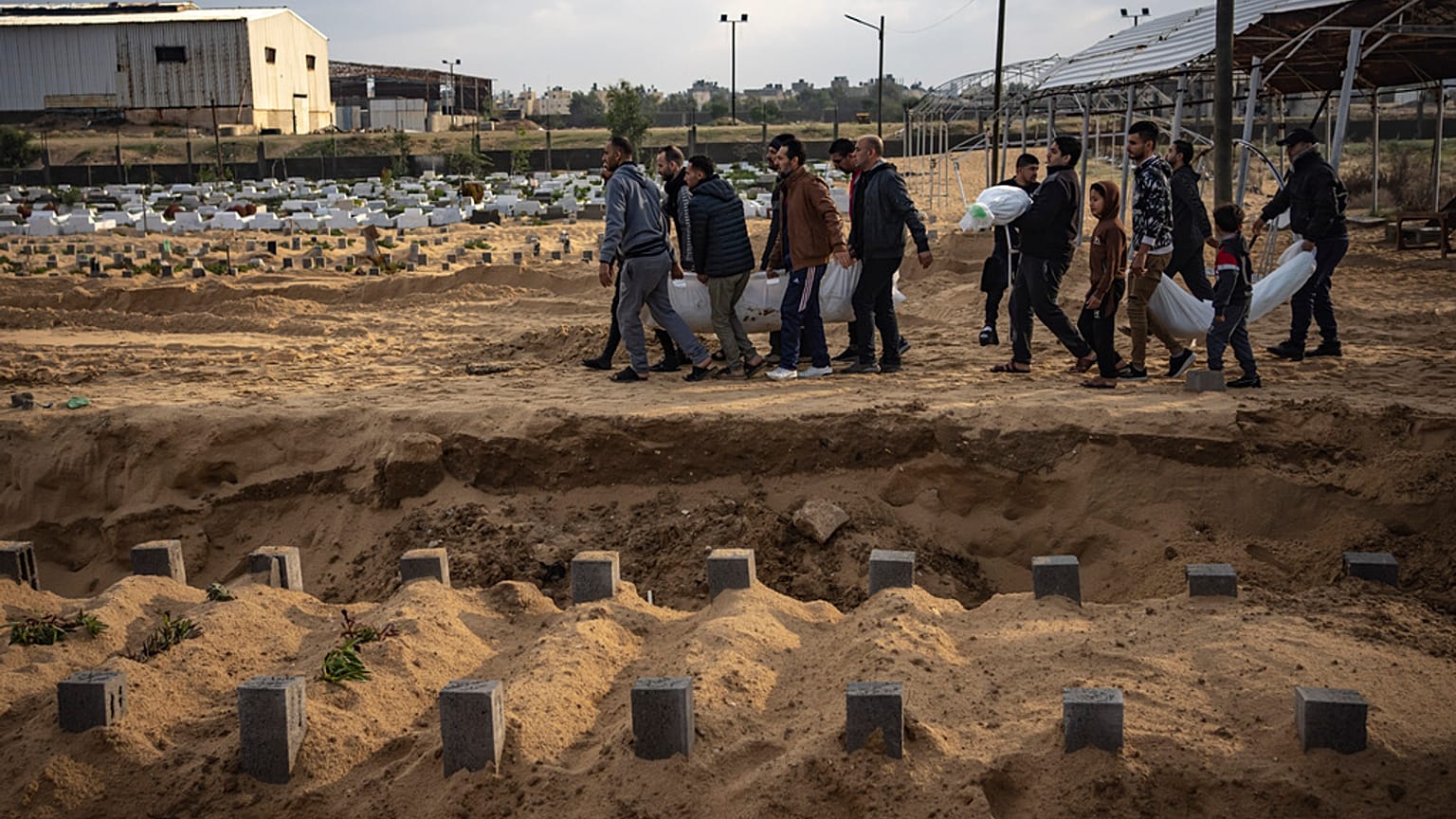 فلسطينيون يحملون جثث أقاربهم الذين قتلوا في القصف الإسرائيلي لقطاع غزة، خلال جنازتهم في مقبرة في رفح، جنوب غزة