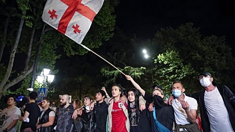 Demonstrators wave a Georgian national flag standing in front of police block during an opposition protest against a bill in Tbilisi, Georgia, on May 2, 2024.