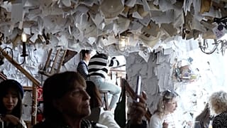 Tourist filming notes on the walls in "The For Sale" pub