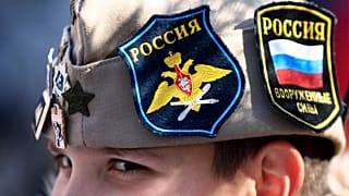 A boy wears Russian insignia on his hat, 12 March 2022