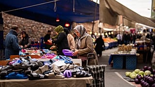 People buy goods and food at a street market in Istanbul (file photo)