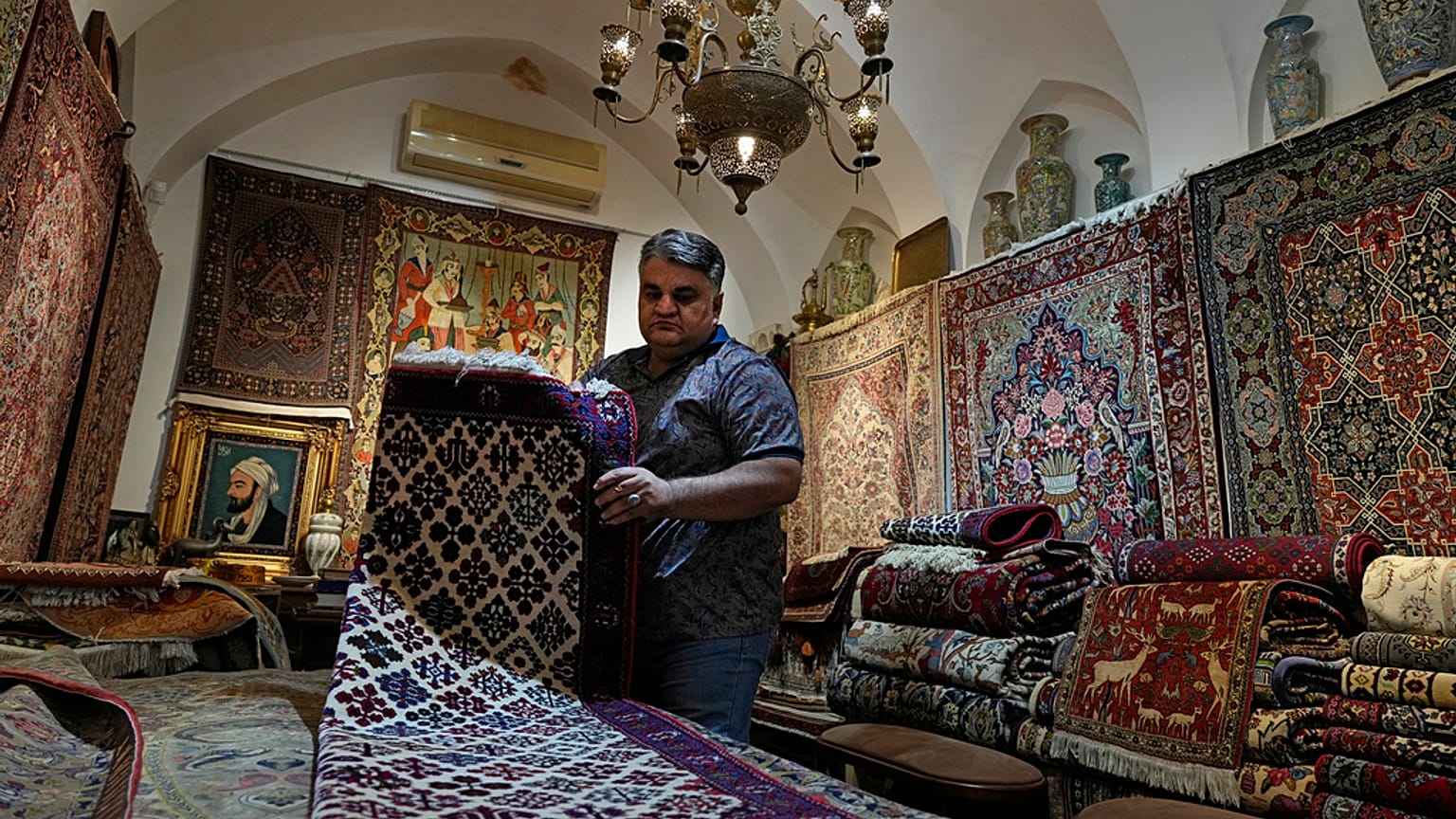 Iranian carpet shop owner Ali Faez works at his shop at the traditional bazaar of the city of Kashan, about 152 miles (245 km) south of the capital Tehran, Iran.