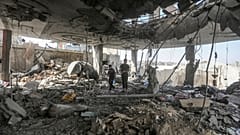 Palestinians stand in the ruins of the Chahine family home, after an overnight Israeli strike that killed at least two adults and five boys and girls in Rafah