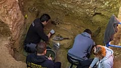 Voluntarios trabajan junto al esqueleto de una víctima antes de su exhumación en una fosa común en una excavación de la Asociación para la Recuperación de la Memoria Histórica