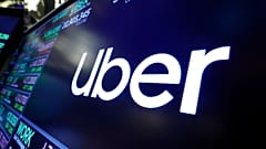 In this Aug. 16, 2019 file photo, the logo for Uber appears above a trading post on the floor of the New York Stock Exchange.