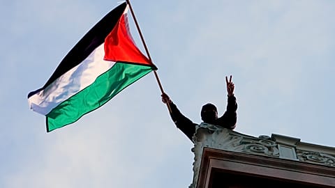  A student protester waves a Palestinian flag above Hamilton Hall on the campus of Columbia University, Tuesday, April 30, 2024, in New York.