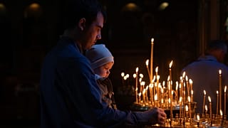 Люди зажигают свечи во время молитвы во Владимирском соборе в Киеве в Великую субботу, 4 мая 2024 года