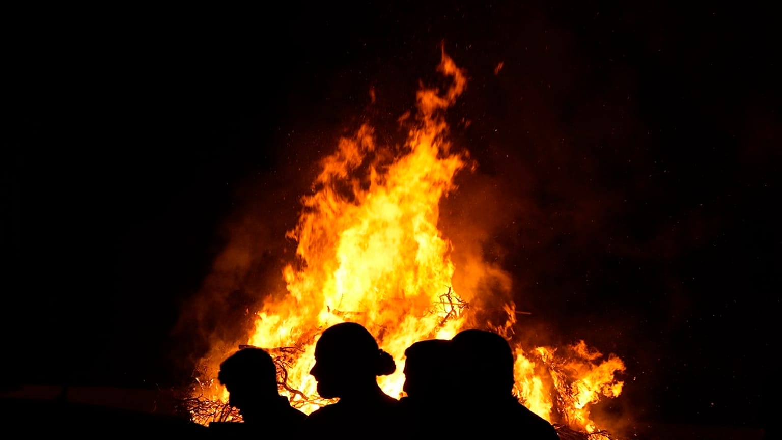 Young men stand in front of the traditional Easter bonfire, or lambradjia, during Orthodox easter celebrations in Cyprus.