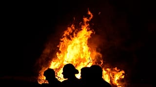 Young men stand in front of the traditional Easter bonfire, or lambradjia, during Orthodox easter celebrations in Cyprus.