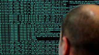 A French solider watches code lines on his computer at the French Defense ministry stand during the International Cybersecurity forum in Lille.