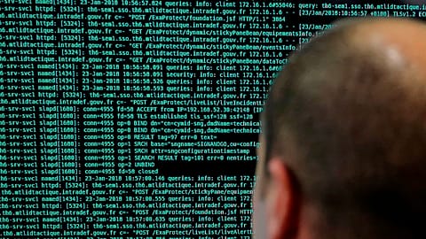 A French solider watches code lines on his computer at the French Defense ministry stand during the International Cybersecurity forum in Lille.