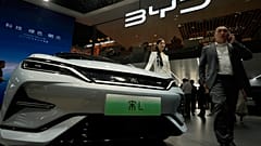 Uma modelo posa perto do automóvel BYD Song L EV durante a Auto China 2024 realizada em Pequim, quinta-feira, 25 de abril de 2024. 