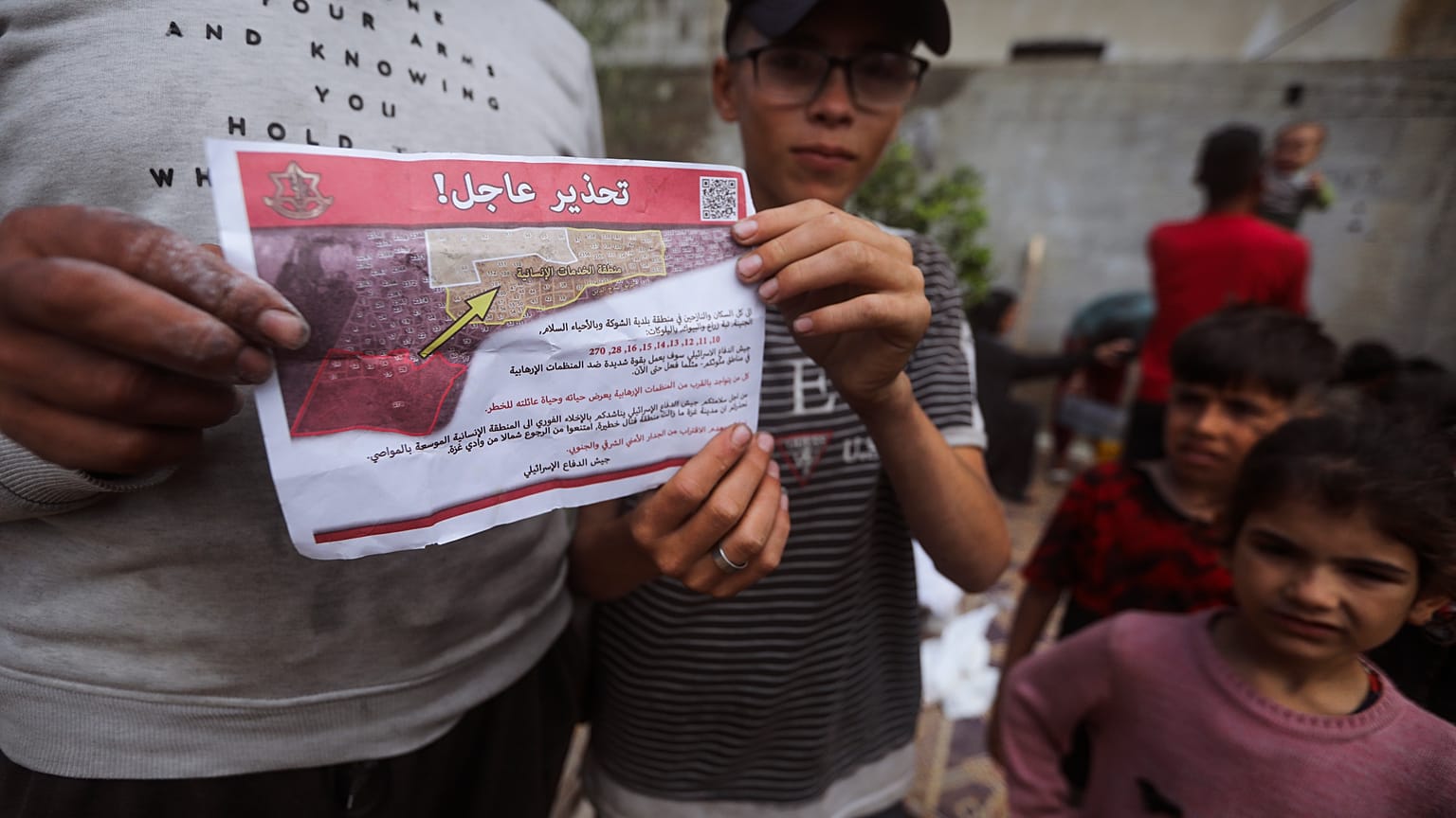 Palestinians hold leaflets dropped by Israeli planes calling on them to evacuate ahead of an Israeli military operation in Rafah, southern Gaza Strip, Monday, May 6, 2024. 