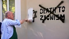 El presidente del Consejo Nacional, Wolfgang Sobotka cubren una pintada antisemita en la fachada de una tienda regentada por judíos en Viena.