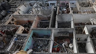 فلسطينيون ينظرون إلى الدمار بعد غارة إسرائيلية على مبنى سكني في رفح، قطاع غزة، الثلاثاء، 7 مايو، 2024.