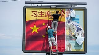Arbeiter kleben eine chinesische Nationalflagge auf eine Plakatwand in Belgrad, Serbien, Dienstag, 7. Mai 2024.