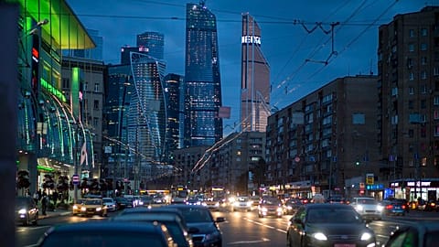 Traffic fills the multi-lane highway, along a main thoroughfare in Moscow, with the modern city skyscrapers illuminating the skyline in Moscow, Russia, Friday, July 8, 2016.