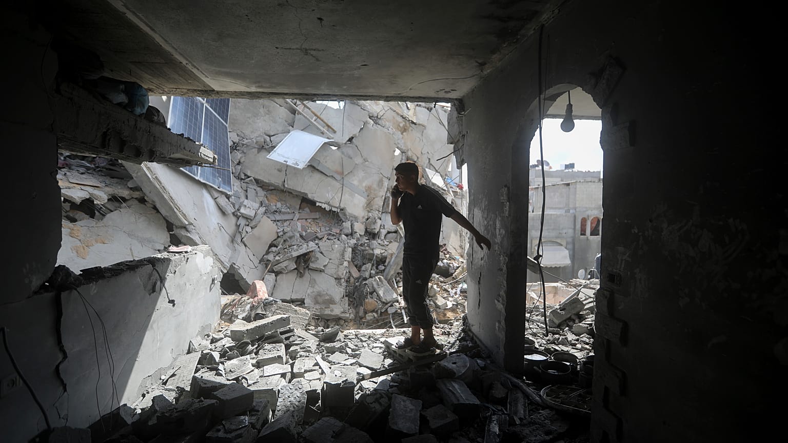 Des Palestiniens observent les dégâts causés par une frappe israélienne sur un immeuble résidentiel à Rafah, le 7 mai 2024.