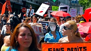 A French sex worker holds a banner reading "Without rights" at a march in Paris, 2 June, 2011