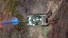 Um tanque russo dispara o seu canhão contra as tropas ucranianas a partir de uma posição perto da fronteira com a Ucrânia, na região de Belgorod, Rússia