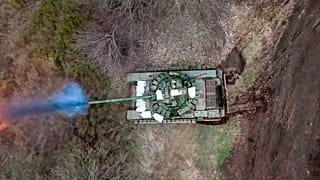 A Russian tank fires its cannon at Ukrainian troops from a position near the border with Ukraine in the Belgorod region, Russia