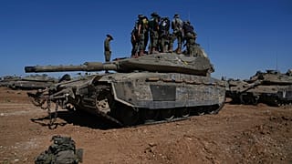 Israeli soldiers work on armored military vehicles at a staging ground near the Israeli-Gaza border, in southern Israel, Wednesday, May 8, 2024. 