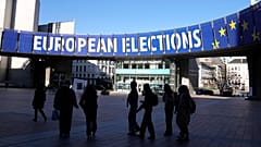 Eine Gruppe steht unter einem Wahlbanner vor dem Europäischen Parlament in Brüssel am 29. April 2024. 