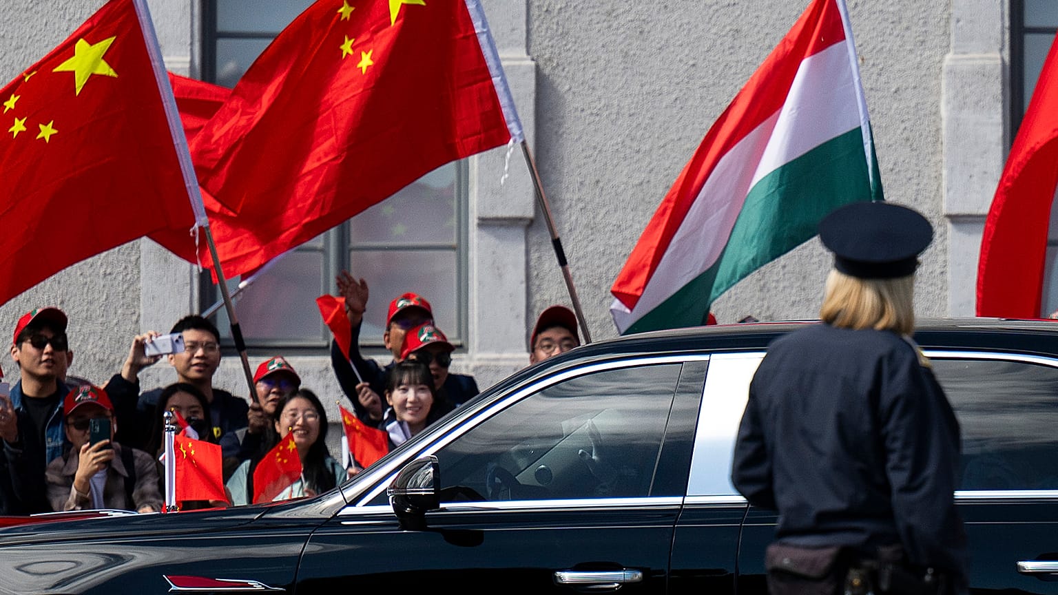 People wave Chinese and Hungarian flags for the Chinese President Xi Jinping outside the Buda Castle in Budapest, 9 May 2024