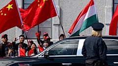 People wave Chinese and Hungarian flags for the Chinese President Xi Jinping outside the Buda Castle in Budapest, 9 May 2024