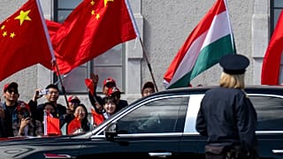 People wave Chinese and Hungarian flags for the Chinese President Xi Jinping outside the Buda Castle in Budapest, 9 May 2024