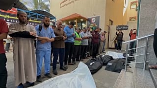 فلسطينيون ينعون الضحايا الذين قُتلوا بغارة إسرائيلية على مبنى سكني في غزة.