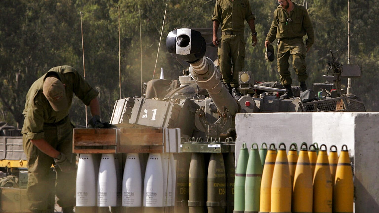 جنود إسرائيليون يُجهّزون معداتهم بجوار قطعة مدفعية خارج قطاع غزة، الجمعة 18 مايو/أيار 2007.