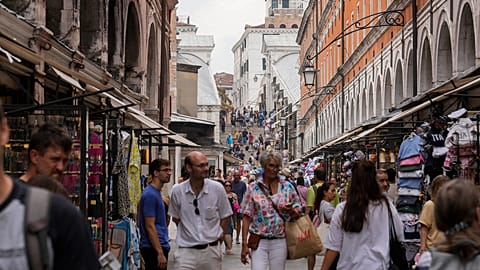 FILE -Tourists walk in a crowded street in Venice, Italy, Wednesday, Sept. 13, 2023.