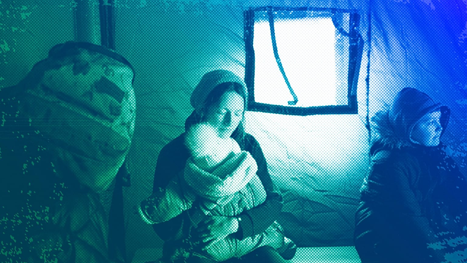 A refugee fleeing the conflict from neighbouring Ukraine holds her baby as she sits in a tent at the Romanian-Ukrainian border, in Siret, February 2022