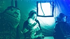 A refugee fleeing the conflict from neighbouring Ukraine holds her baby as she sits in a tent at the Romanian-Ukrainian border, in Siret, February 2022