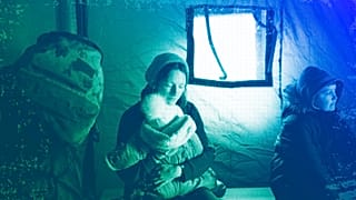 A refugee fleeing the conflict from neighbouring Ukraine holds her baby as she sits in a tent at the Romanian-Ukrainian border, in Siret, February 2022