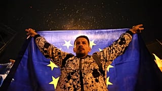 Διαδηλωτής κρατά σημαία της ΕΕ κατά τη διάρκεια συγκέντρωσης διαμαρτυρίας κατά του "ρωσικού νόμου" στην Τιφλίδα της Γεωργίας, Σάββατο 11 Μαΐου 2024.